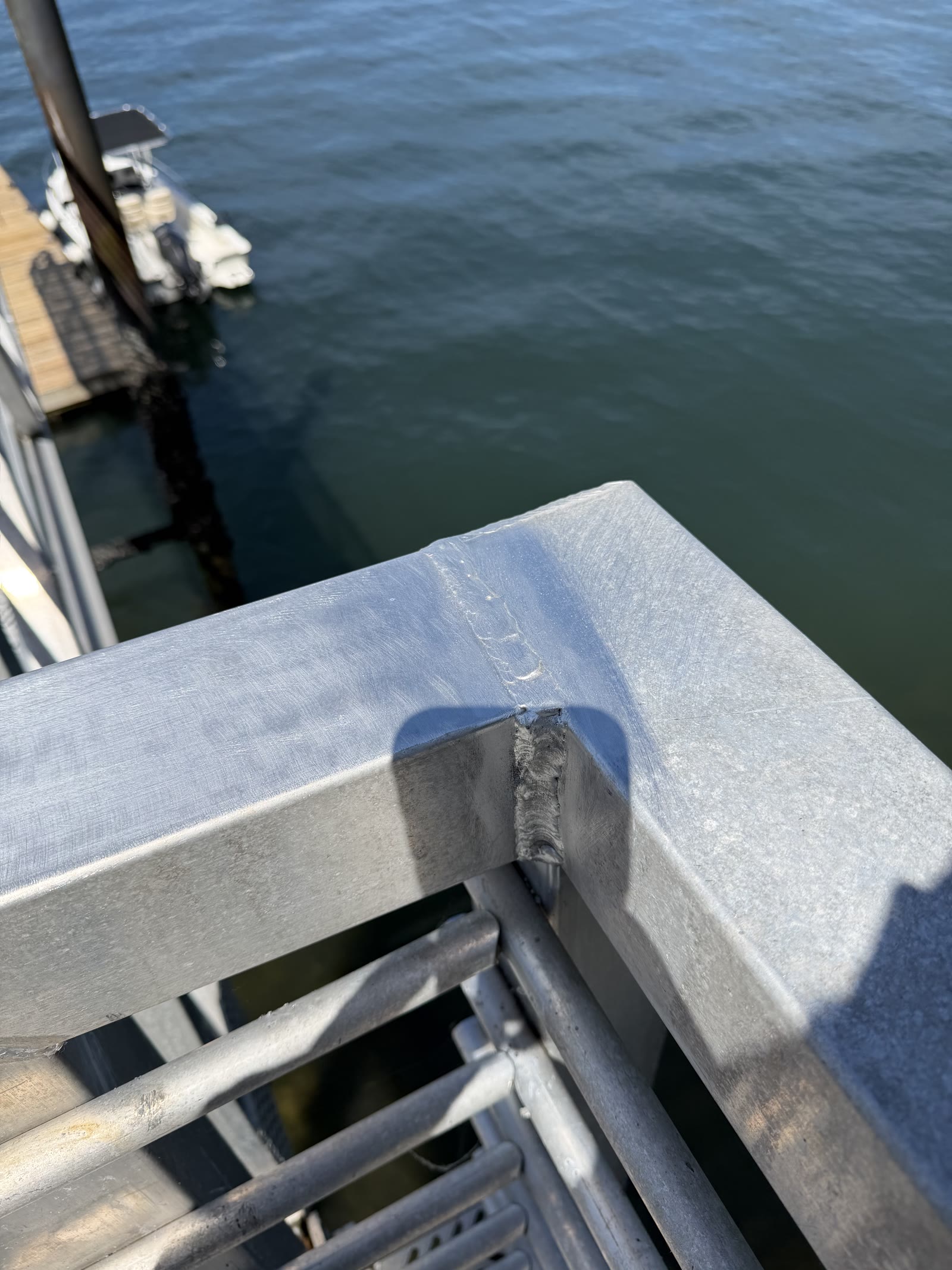 Repaired aluminum gangway railing corner with finished weld